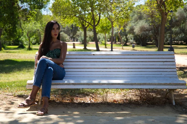 Gyönyörű Spanyol Fekete Hajjal Egy Fehér Padon Parkban Egyedül Van — Stock Fotó