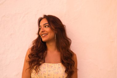 Beyaz arka planda uzun kıvırcık saçlı güzel bir kadın farklı ifadeler kullanır. Kahkaha, nefret, üzüntü, gülümseme, yorgunluk, hayranlık, şaşkınlık, mutluluk. Farklı ifadeleri kavra