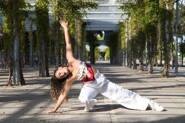 Latin kadın, genç ve güzel dans eden modern dans parktaki sokakta ve farklı ifadeler ve duruşlar sergiliyor. Konsept dansı, hip hop, dans, sanat, aksiyon, güzellik, gençlik sanatı.