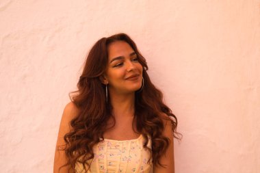 Beyaz arka planda uzun kıvırcık saçlı güzel bir kadın farklı ifadeler kullanır. Kahkaha, nefret, üzüntü, gülümseme, yorgunluk, hayranlık, şaşkınlık, mutluluk. Farklı ifadeleri kavra