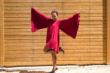 Genç ve güzel Afro-Amerikalı bir kadın tahta bir arka planda farklı vücut hareketleri ve ifadeleri yapıyor. Mutlu, üzgün, eğlenceli, düşünceli. İfadeleri kavra.