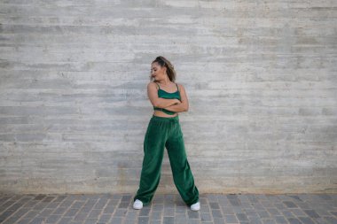 Latin kadın, genç ve güzel dans eden modern dans sokaktaki gri çimento arka planında farklı ifadeler ve duruşlar sergiliyor. Konsept dansı, hip hop, dans, sanat, aksiyon, gençlik sanatı.