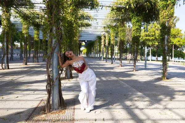 Latin kadın, genç ve güzel dans eden modern dans parktaki sokakta ve farklı ifadeler ve duruşlar sergiliyor. Konsept dansı, hip hop, dans, sanat, aksiyon, güzellik, gençlik sanatı.