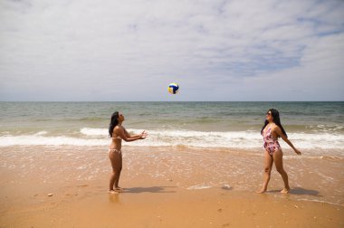 Sahilde Boley oynayan iki genç ve güzel kadın. Kadınlar oyundan ve cennetteki kumsaldan zevk alıyorlar. Tatiller ve seyahatler.