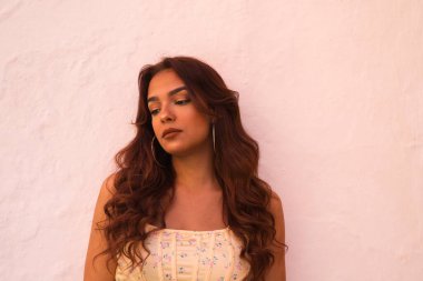 Beyaz arka planda uzun kıvırcık saçlı güzel bir kadın farklı ifadeler kullanır. Kahkaha, nefret, üzüntü, gülümseme, yorgunluk, hayranlık, şaşkınlık, mutluluk. Farklı ifadeleri kavra