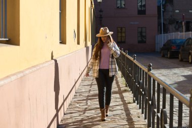 Young and beautiful Spanish woman walks happily and is talking on a mobile phone. Telecommunications concept
