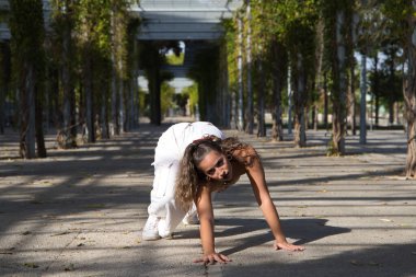 Latin kadın, genç ve güzel dans eden modern dans parktaki sokakta ve farklı ifadeler ve duruşlar sergiliyor. Konsept dansı, hip hop, dans, sanat, aksiyon, güzellik, gençlik sanatı.