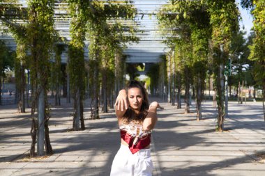 Latin kadın, genç ve güzel dans eden modern dans parktaki sokakta ve farklı ifadeler ve duruşlar sergiliyor. Konsept dansı, hip hop, dans, sanat, aksiyon, güzellik, gençlik sanatı.