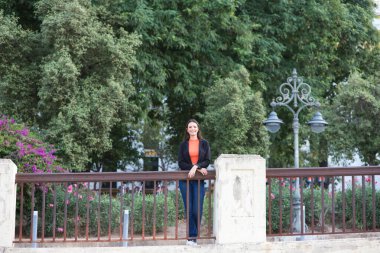 pretty young Spanish woman looking over the railing to the horizon. The woman is happy and content because she looks to the future with interest.