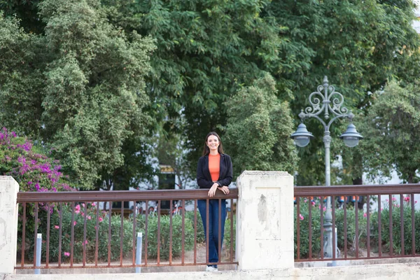 stock image pretty young Spanish woman looking over the railing to the horizon. The woman is happy and content because she looks to the future with interest.