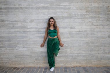 Latin kadın, genç ve güzel dans eden modern dans sokaktaki gri çimento arka planında farklı ifadeler ve duruşlar sergiliyor. Konsept dansı, hip hop, dans, sanat, aksiyon, gençlik sanatı.