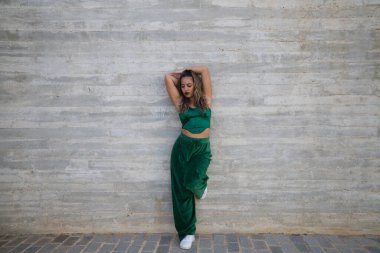 Latin kadın, genç ve güzel dans eden modern dans sokaktaki gri çimento arka planında farklı ifadeler ve duruşlar sergiliyor. Konsept dansı, hip hop, dans, sanat, aksiyon, gençlik sanatı.