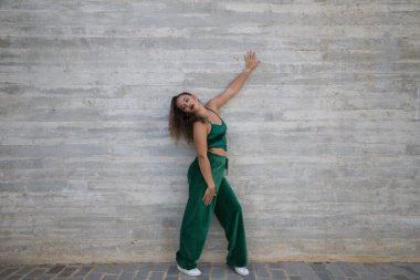 Latin kadın, genç ve güzel dans eden modern dans sokaktaki gri çimento arka planında farklı ifadeler ve duruşlar sergiliyor. Konsept dansı, hip hop, dans, sanat, aksiyon, gençlik sanatı.