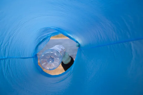 stock image Detail of a volunteer's hand putting a plastic bottle in the bag. Photo taken from below. Concept of Earth Day and World Environment Day June 5.