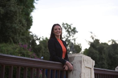 pretty young Spanish woman looking over the railing to the horizon. The woman is happy and content because she looks to the future with interest.