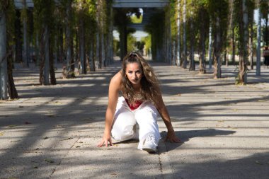 Latin kadın, genç ve güzel dans eden modern dans parktaki sokakta ve farklı ifadeler ve duruşlar sergiliyor. Konsept dansı, hip hop, dans, sanat, aksiyon, güzellik, gençlik sanatı.