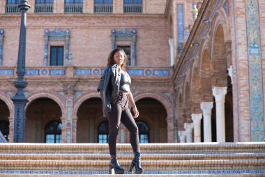 Genç ve güzel siyah Latin kadın Seville şehrinin en önemli meydanını ziyaret ediyor. Kadın uluslararası moda etkinliklerinin yapıldığı meydanın merdivenlerinden iniyor..