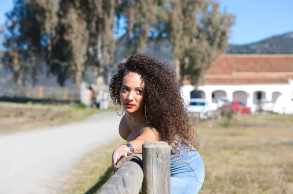 Curly Haired Brunette Woman Has Her Arm Stretched Wooden Fence — Stock Photo, Image