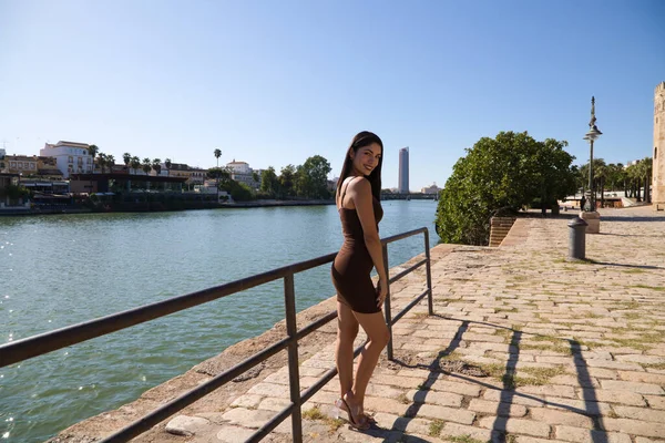 来自南美 穿着短裙的年轻貌美的女人正在塞维尔度假 在河的后面 女人笑了 表达了不同的意思 旅行和假期 — 图库照片