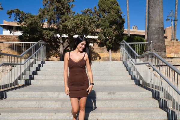 短いドレスを着た南アメリカの若く美しい女性が階段を歩いています 彼女はヨーロッパで休暇をとっているのでその女性は幸せです 旅行と休暇 — ストック写真