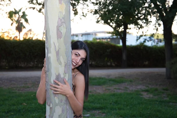 南アメリカの美しい若い女性が黄金の時間に森の中で木を抱いていました 自然と接触する人々の環境とリラクゼーションの日 — ストック写真
