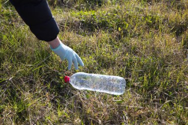 Ormandan plastik şişe toplayan bir gönüllünün ayrıntıları. Dünya Günü ve Dünya Çevre Günü kavramı 5 Haziran.