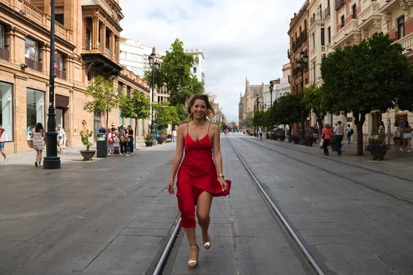 Büyük Bir Şehirde Tramvay Rayları Arasında Koşan Kırmızı Ipek Elbiseli — Stok fotoğraf