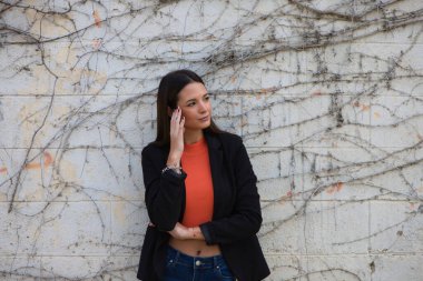 young beautiful woman leaning on a wall makes different expressions, sad, melancholic, happy, exhausted, dazed, smiling, thinking, tired. Concept different expressions.