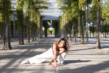 Latin kadın, genç ve güzel dans eden modern dans parktaki sokakta ve farklı ifadeler ve duruşlar sergiliyor. Konsept dansı, hip hop, dans, sanat, aksiyon, güzellik, gençlik sanatı.