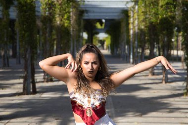 Latin kadın, genç ve güzel dans eden modern dans parktaki sokakta ve farklı ifadeler ve duruşlar sergiliyor. Konsept dansı, hip hop, dans, sanat, aksiyon, güzellik, gençlik sanatı.