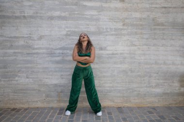 Latin kadın, genç ve güzel dans eden modern dans sokaktaki gri çimento arka planında farklı ifadeler ve duruşlar sergiliyor. Konsept dansı, hip hop, dans, sanat, aksiyon, gençlik sanatı.