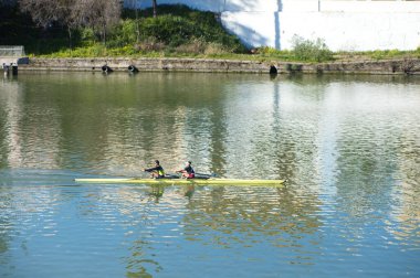 İki kişi Guadalquivir nehrinde, Seville 'de çift kano eğitimi alıyor. Kürekçiler olimpiyat oyunlarına hazırlanıyor..