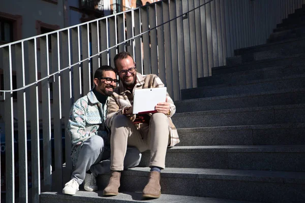 Dva Mladí Gayové Sedí Schodech Notebook Dívá Ukazuje Obrazovku Pár — Stock fotografie