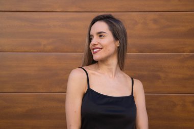 Siyah tişört ve ahşap arka planda kot giyen genç ve güzel sarışın kadın farklı ifadeler ve duruşlar sergileyen fotoğraflar için poz veriyor. Güzellik ve moda konsepti.