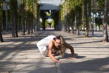 Latin kadın, genç ve güzel dans eden modern dans parktaki sokakta ve farklı ifadeler ve duruşlar sergiliyor. Konsept dansı, hip hop, dans, sanat, aksiyon, güzellik, gençlik sanatı.