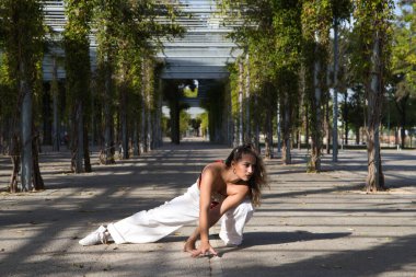 Latin kadın, genç ve güzel dans eden modern dans parktaki sokakta ve farklı ifadeler ve duruşlar sergiliyor. Konsept dansı, hip hop, dans, sanat, aksiyon, güzellik, gençlik sanatı.