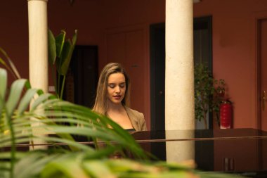 Blonde woman playing the piano. The woman is happy feeling the music.