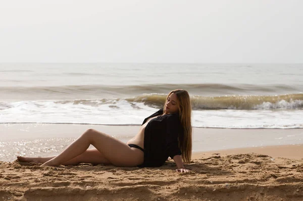 해변에 아름다운 금발의 여자는 일몰을 즐기면서 휴식을 취하고 여자는 진지하고 — 스톡 사진