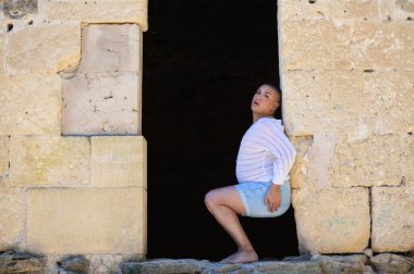 İkili olmayan Latince ve genç kişi, bir kalede kapının deliğinde farklı vücut ifadeleri yapıyor. Çeşitlilik, homoseksüellik ve gay gururu kavramı