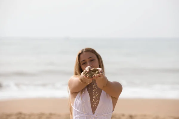 Mulher Loira Muito Jovem Vestido Branco Derrama Areia Entre Mãos — Fotografia de Stock