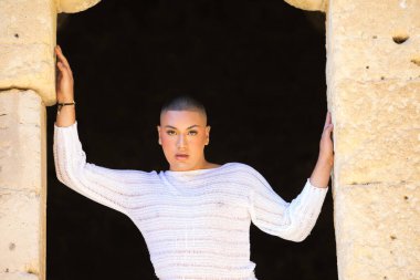 İkili olmayan Latince ve genç kişi, bir kalede kapının deliğinde farklı vücut ifadeleri yapıyor. Çeşitlilik, homoseksüellik ve gay gururu kavramı