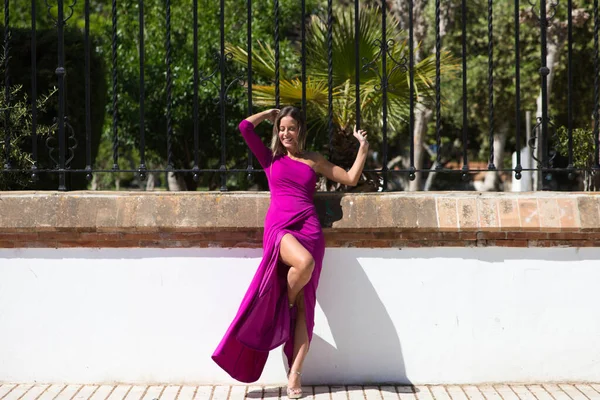 Mor Elbiseli Güzel Sarışın Bir Kadın Park Çitlerine Yaslanmış Fotoğraflara — Stok fotoğraf