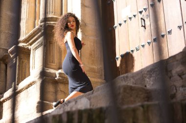 İspanya 'nın güneyindeki barok kilisesinin kapısının yanındaki güzel, koyu renk saçlı İspanyol kadın tatilde birkaç gün geçirecek. Tatil ve seyahat kavramı.