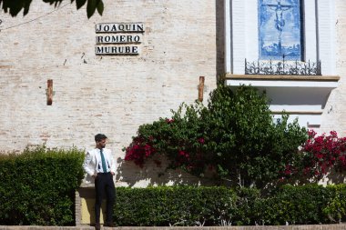 Sakallı ve beyaz ceketli yakışıklı genç adam İspanya 'daki Seville şehrini ziyaret ediyor. Adam Santa Cruz bölgesindeki ünlü bir meydanda. Seyahat ve tatil konsepti
