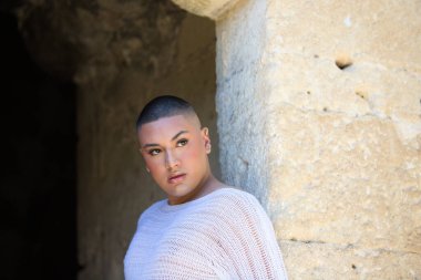 İkili olmayan Latince ve genç kişi, bir kalede kapının deliğinde farklı vücut ifadeleri yapıyor. Çeşitlilik, homoseksüellik ve gay gururu kavramı