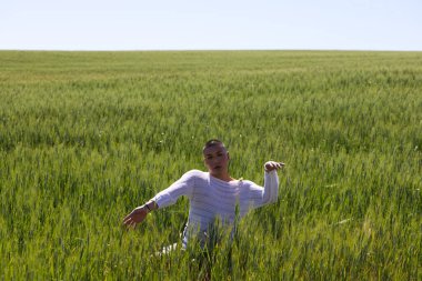 İkili olmayan Latince ve genç eşcinsel insanlar yeşil buğday tarlaları arasında el ve kollarıyla farklı vücut hareketleri yaparak eğleniyorlar. Çeşitlilik, eşcinsellik ve insan hakları kavramı