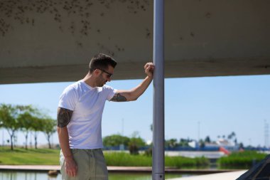 Güneş gözlüklü, güneş gözlüklü, sokak lambasına yaslanmış yakışıklı bir genç. Adam üzgün, nostaljik ve depresif. Ruh sağlığı kavramı