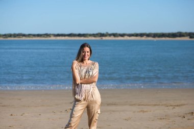 Güzel sarışın kadın İspanya 'nın güney kıyısındaki sahil boyunca yürüyor. Kadın mutlu, gülümsüyor ve güneşli günün tadını çıkarıyor. Seyahat ve tatil konsepti