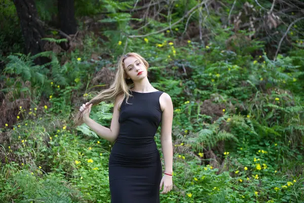 Siyah Giyinmiş Genç Güzel Sarışın Kadın Farklı Duruş Ifadelerle Ormanda Stok Fotoğraf