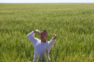 İkili olmayan Latince ve genç eşcinsel insanlar yeşil buğday tarlaları arasında el ve kollarıyla farklı vücut hareketleri yaparak eğleniyorlar. Çeşitlilik, eşcinsellik ve insan hakları kavramı